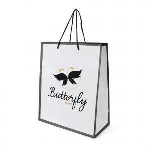 Medium sized white glossy paper bag with coloured trim and rope handles. Made with 157gsm art paper.