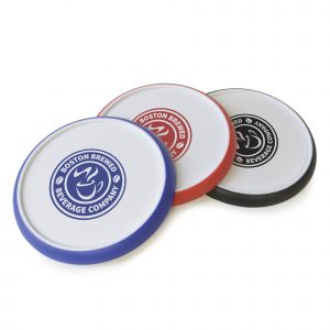 Circular white plastic coaster with coloured silicone edge for a better grip.