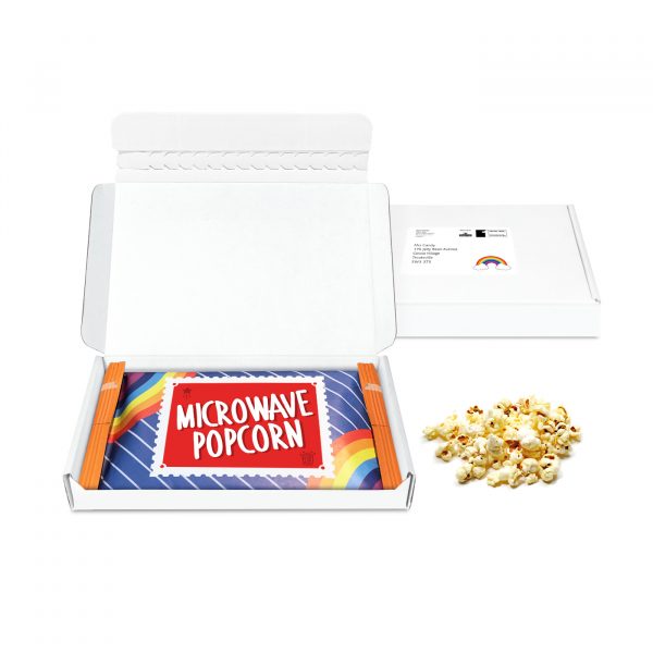 A slim white postal box that comes filled with microwave popcorn wrapped in branded kraft film.