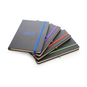 80 lined sheet notebook made from recycled materials. Your logo is engraved to reveal a coloured undercoat. With coloured ribbon bookmark, elastic pen loop and elastic closure